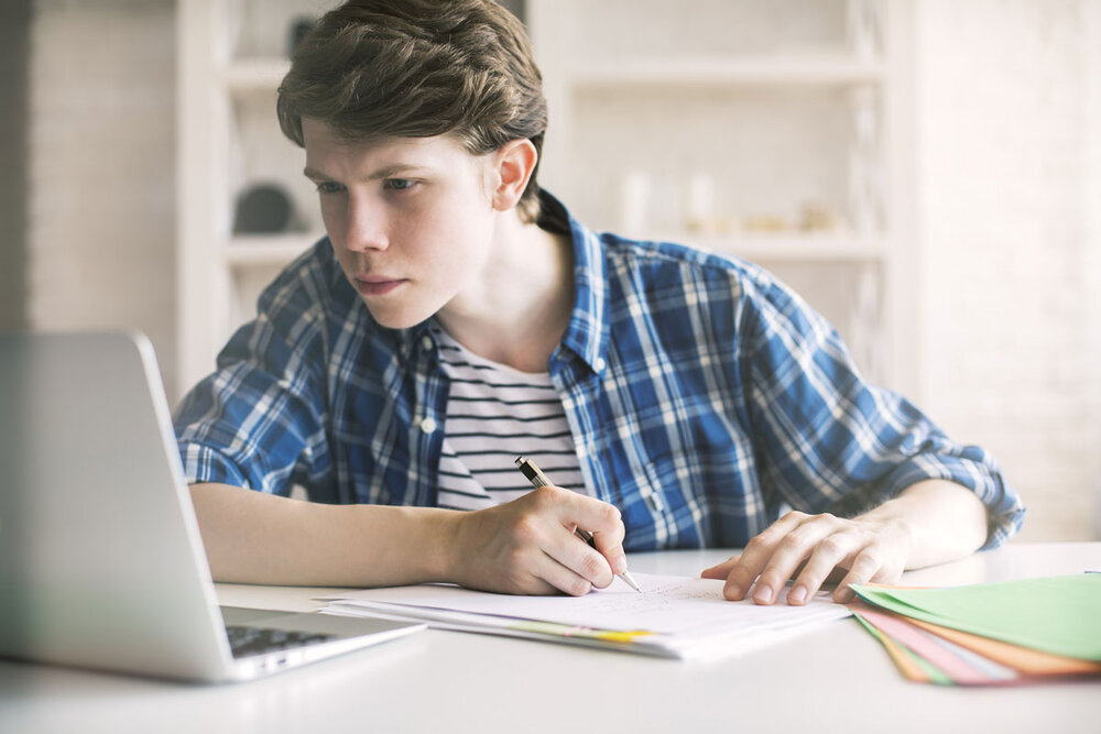 A person sitting at a table using a laptop